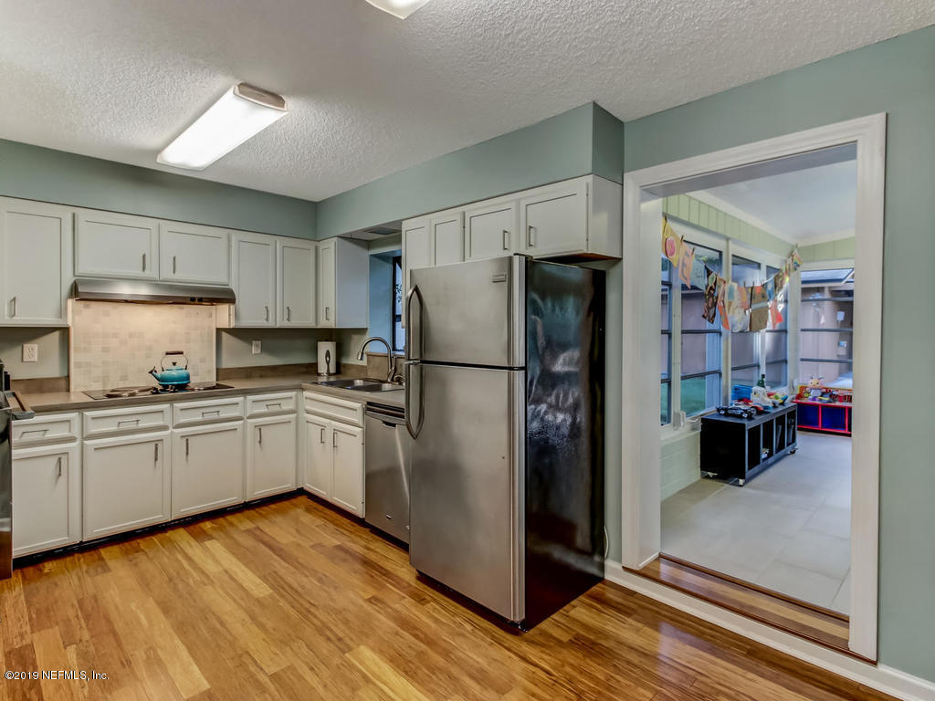 4629 Homestead Road Jacksonville, FL 32210 - Photo 8 of 27 a kitchen with a refrigerator and a stove top oven