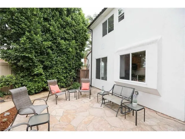a view of two chairs and a table in the back yard