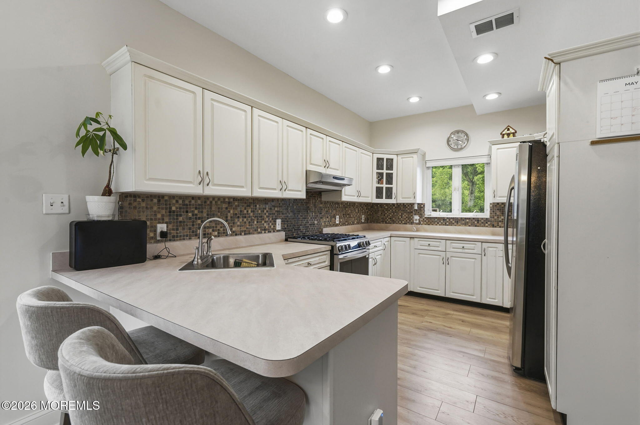 438 Bennetts Mills Road Jackson, NJ 08527 - Photo 10 of 42 a kitchen with stainless steel appliances granite countertop a refrigerator a stove top oven a sink dishwasher and white cabinets with wooden floor