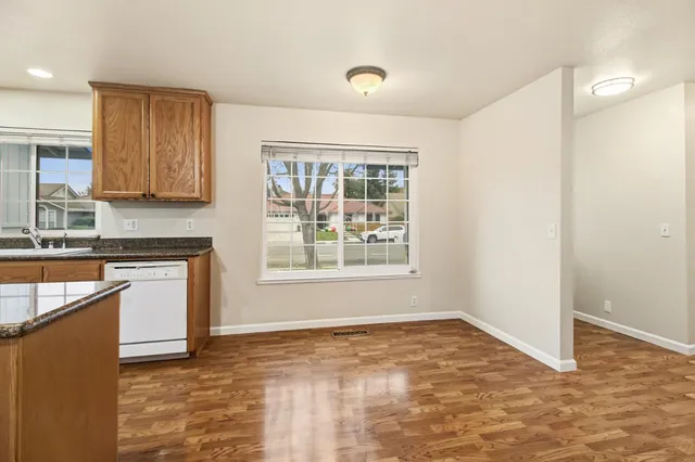 a kitchen with granite countertop a stove a sink and a refrigerator