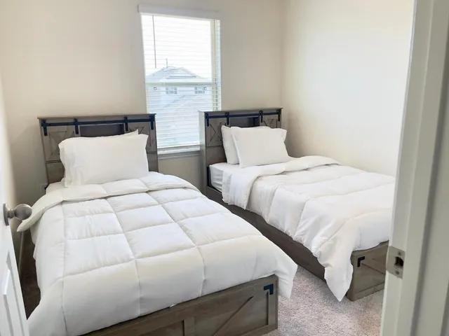 a bedroom with two beds and a large window