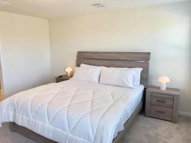 a bedroom with a bed and a lamp