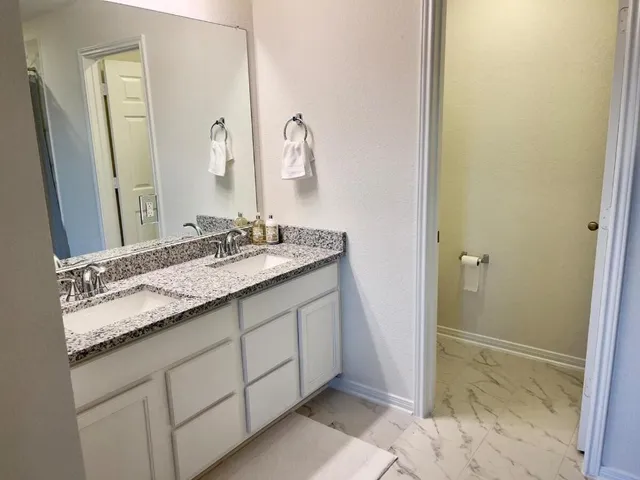 a bathroom with a granite countertop sink and a mirror