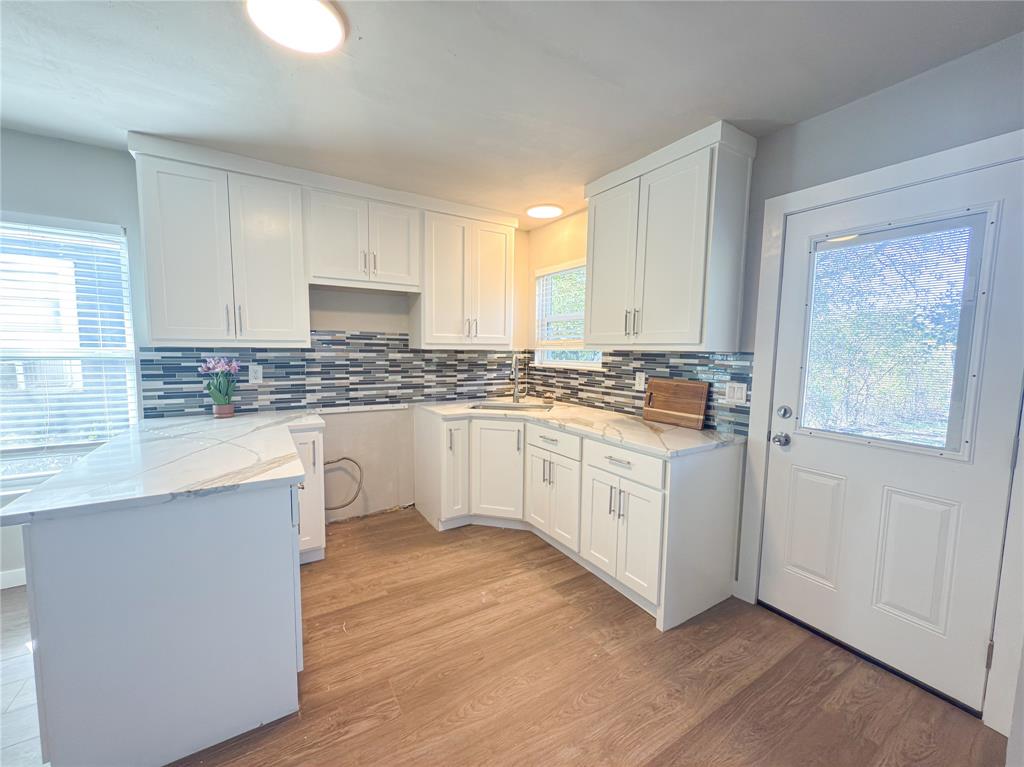 2431 Marfa Avenue Dallas, TX 75216 - Photo 17 of 39 a kitchen with granite countertop white cabinets and white appliances with wooden floor