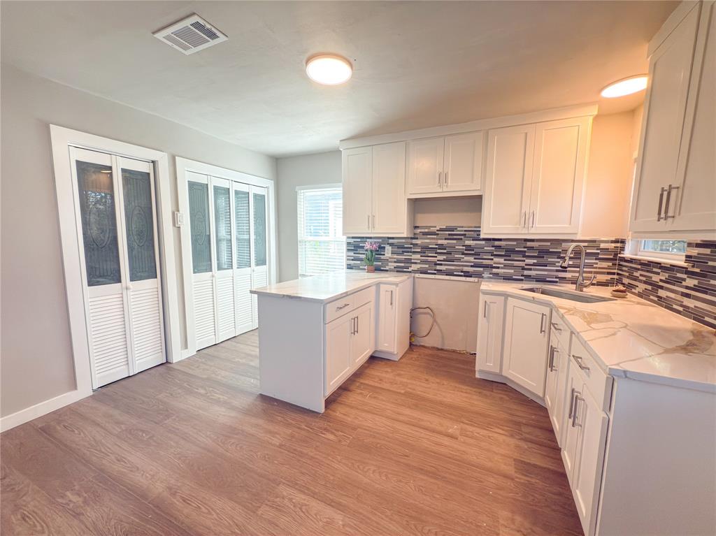 2431 Marfa Avenue Dallas, TX 75216 - Photo 18 of 39 a kitchen with granite countertop a stove top oven sink and cabinets