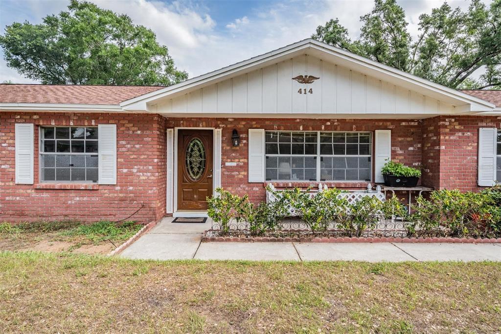 a front view of a house with a yard and potted plants