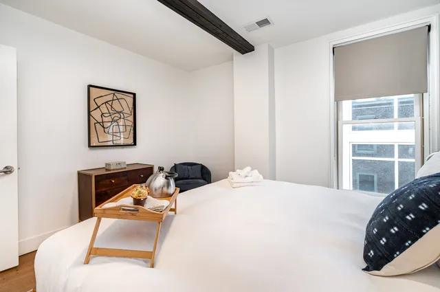 a bedroom with a bed a couch and a window