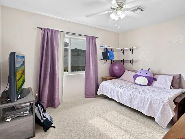 a bedroom with a bed and a flat tv screen