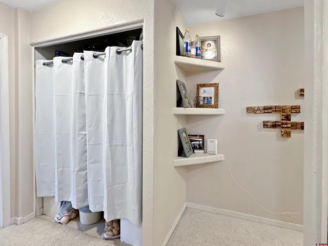 a view of a hallway with two white cabinet