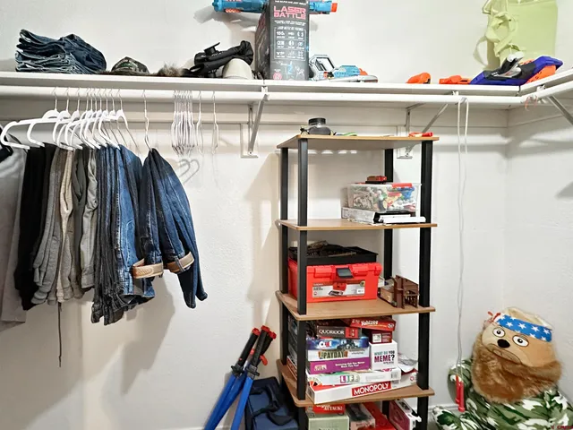 a view of walk in closet with clothes and shoes