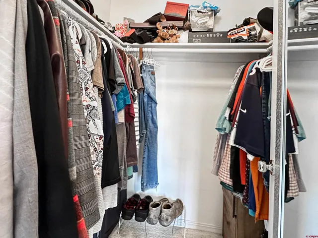 a view of walk in closet with clothes and shoes