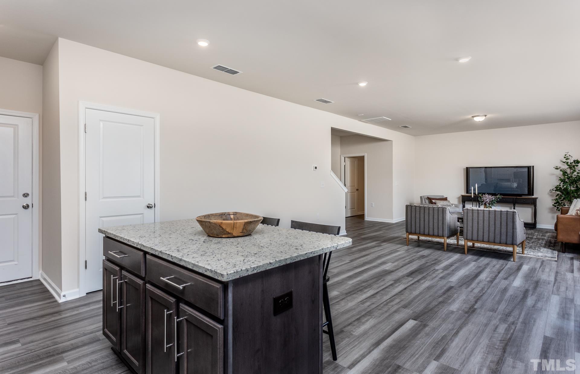 3505 Dragonfly River Court Raleigh, NC 27604 - Photo 11 of 28 a kitchen with granite countertop a stove and a wooden floor