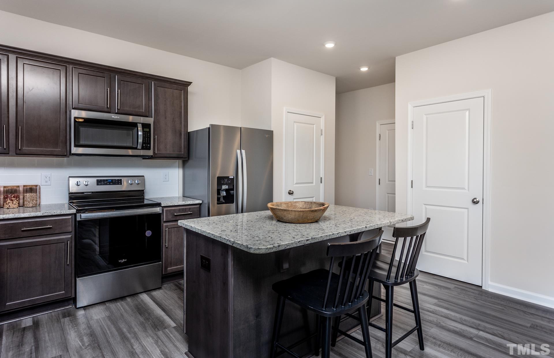 3505 Dragonfly River Court Raleigh, NC 27604 - Photo 12 of 28 a kitchen with a wooden floor and stainless steel appliances