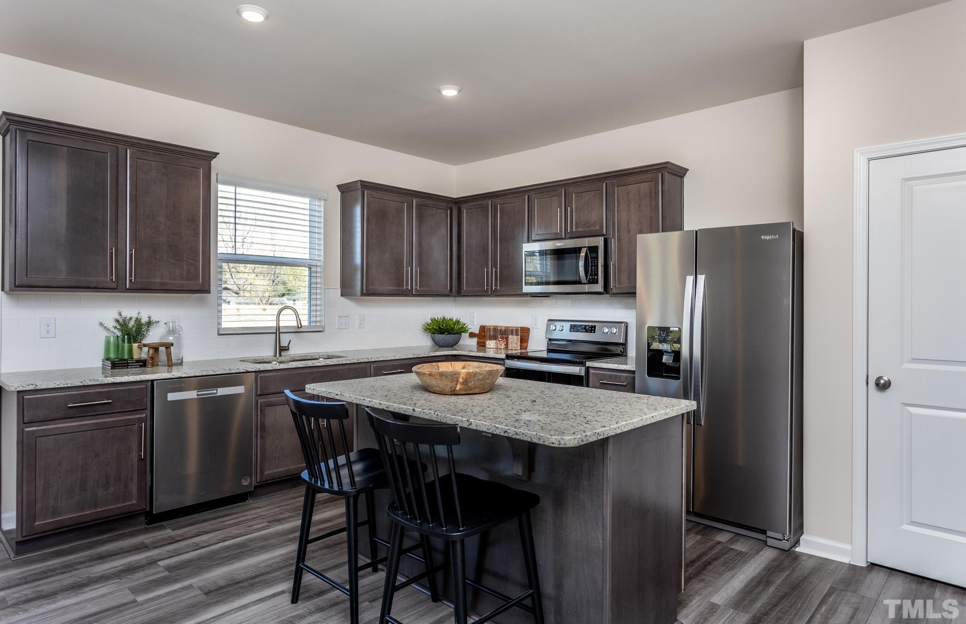 3505 Dragonfly River Court Raleigh, NC 27604 - Photo 13 of 28 a kitchen with a refrigerator a stove a sink and dishwasher with wooden floor
