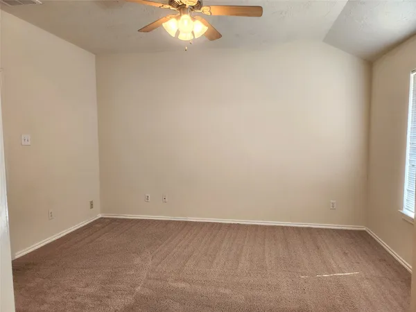 an empty room with a chandelier fan