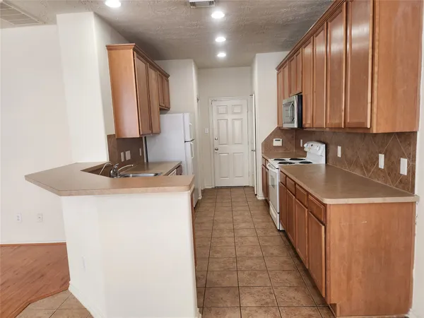 a kitchen with stainless steel appliances a sink stove and cabinets