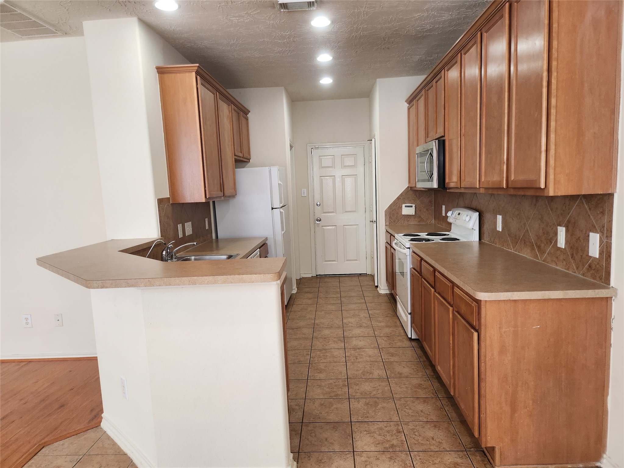 11509 Hackmatack Way Houston, TX 77066 - Photo 6 of 16 a kitchen with stainless steel appliances a sink stove and cabinets