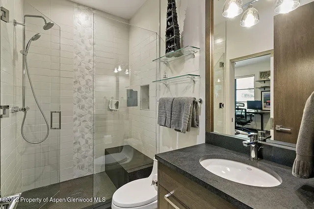 a bathroom with a granite countertop sink toilet and shower