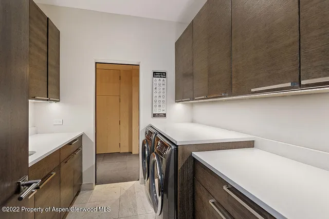 a utility room with cabinets washer and dryer