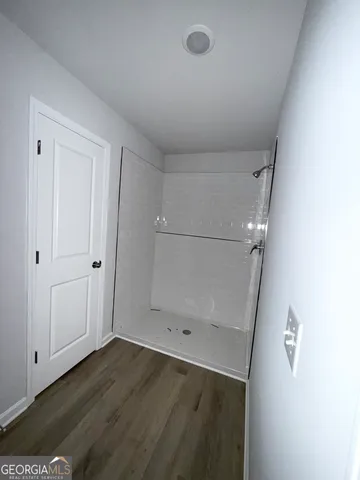 an empty room with wooden floor and mirror