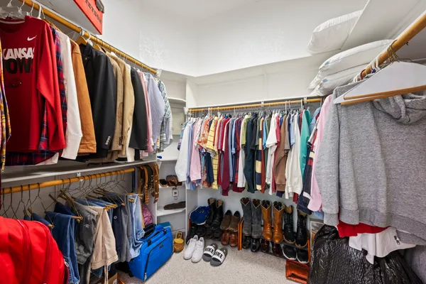 a view of walk in closet with clothes and shoes