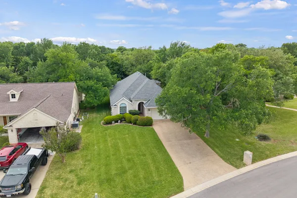 an aerial view of residential houses with outdoor space and trees