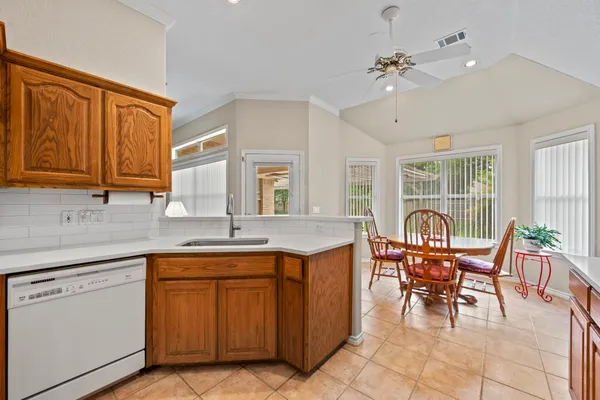 a open kitchen with granite countertop a sink cabinets and dining table