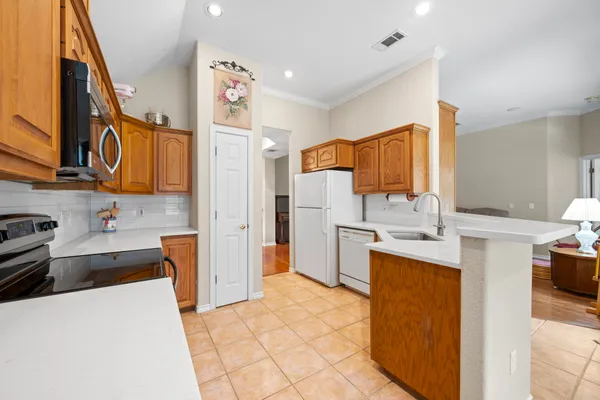 a kitchen with stainless steel appliances a stove refrigerator sink and cabinets