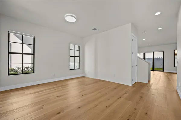 a view of empty room with wooden floor and fan