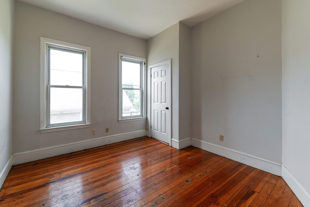 107 Devon Street Boston, MA 02121 - Photo 6 of 9 an empty room with wooden floor and windows