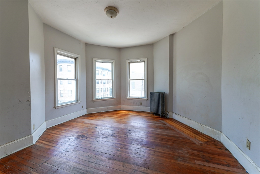 107 Devon Street Boston, MA 02121 - Photo 7 of 9 a view of empty room with wooden floor and fan
