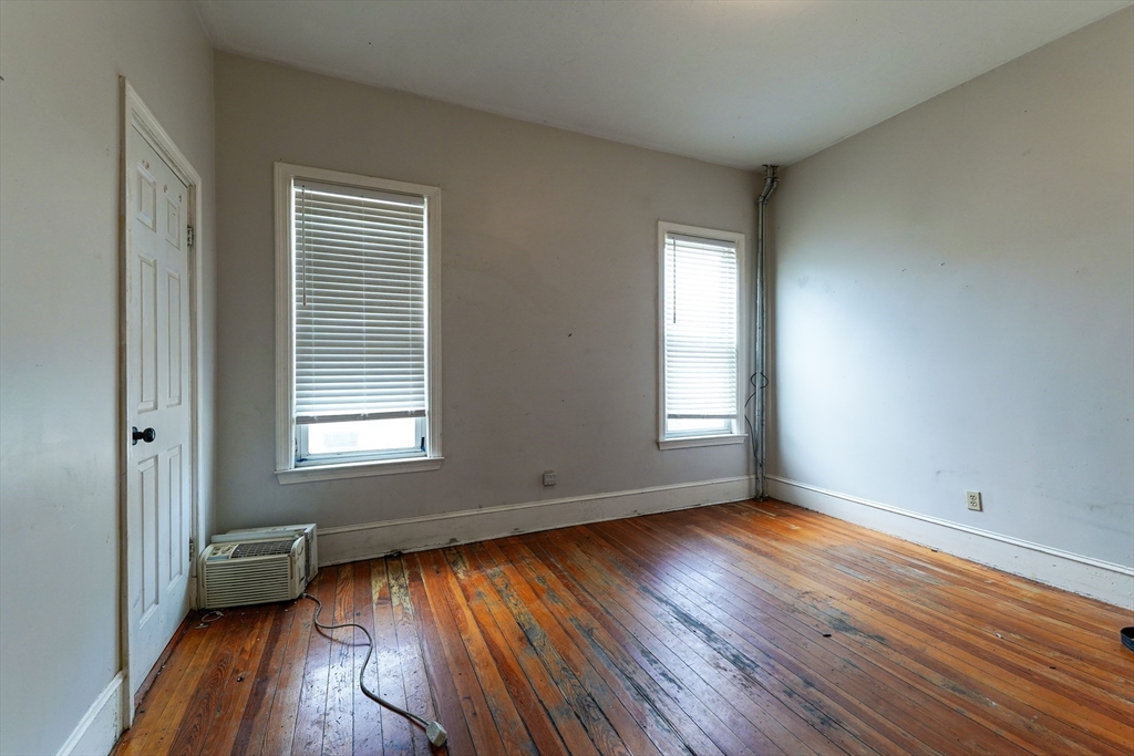 107 Devon Street Boston, MA 02121 - Photo 8 of 9 an empty room with wooden floor and windows