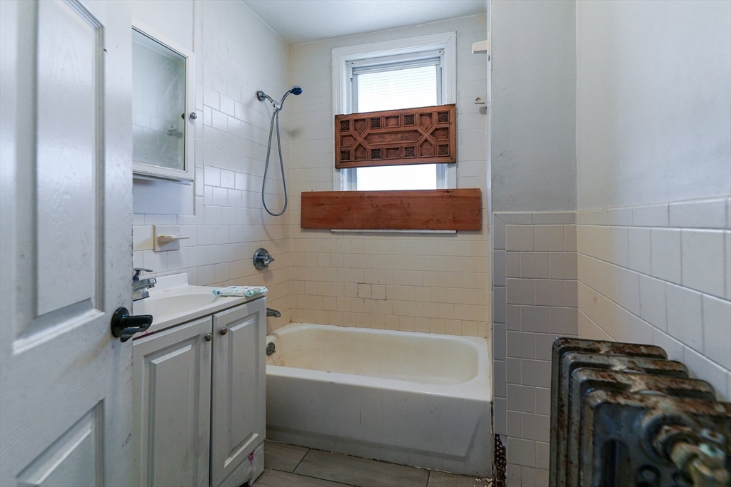 107 Devon Street Boston, MA 02121 - Photo 9 of 9 a bathroom with a tub sink and mirror