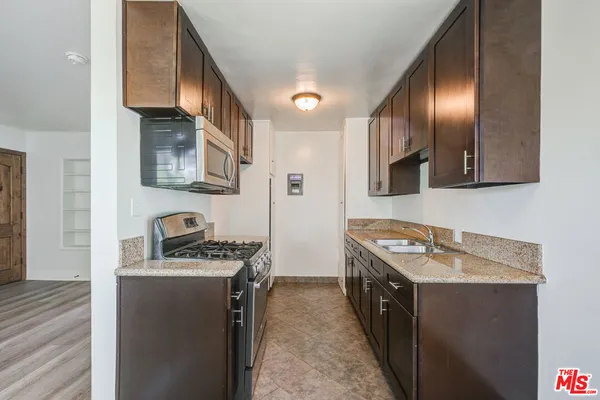 a kitchen with stainless steel appliances granite countertop a stove a sink and a refrigerator
