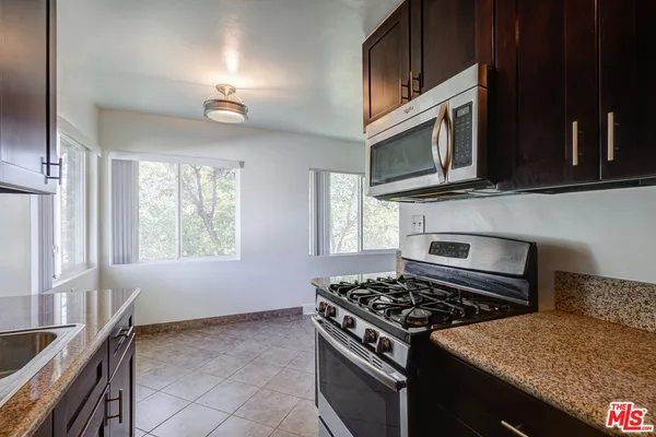 a kitchen with stainless steel appliances granite countertop a stove and a microwave
