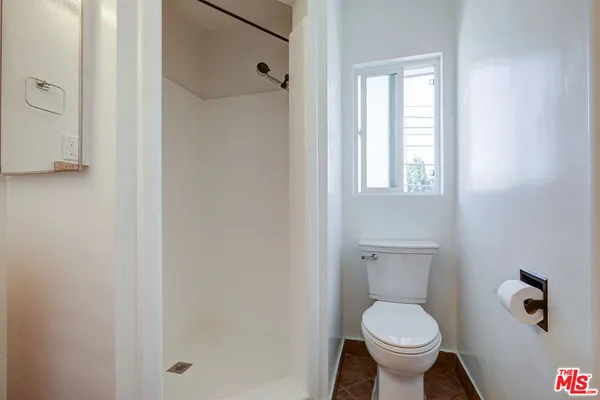 a bathroom with a granite countertop toilet a sink and a mirror