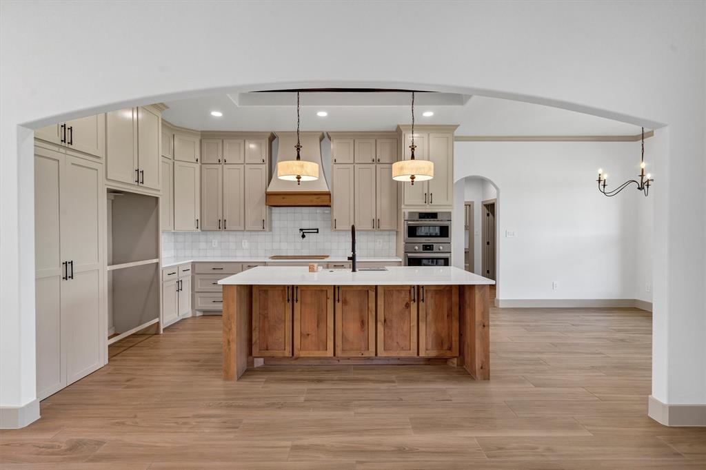 5006 Stover Way Granbury, TX 76049 - Photo 6 of 40 a large kitchen with stainless steel appliances a large counter top a stove a refrigerator and a sink