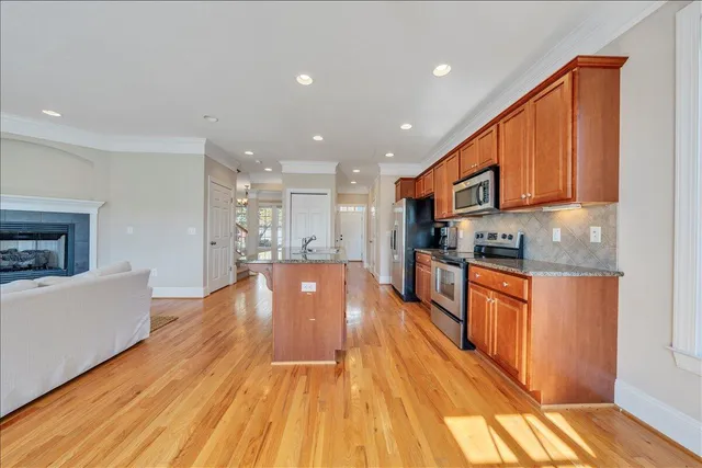 a large white kitchen with stainless steel appliances granite countertop a stove a sink and a refrigerator