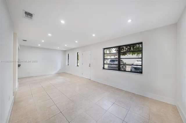 an empty room with windows and ceiling fan