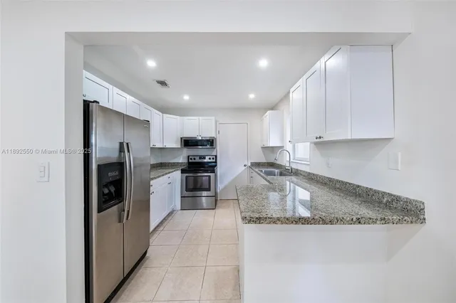 a kitchen with a refrigerator a stove and a sink