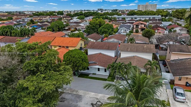 a aerial view of a house with a yard and potted plants