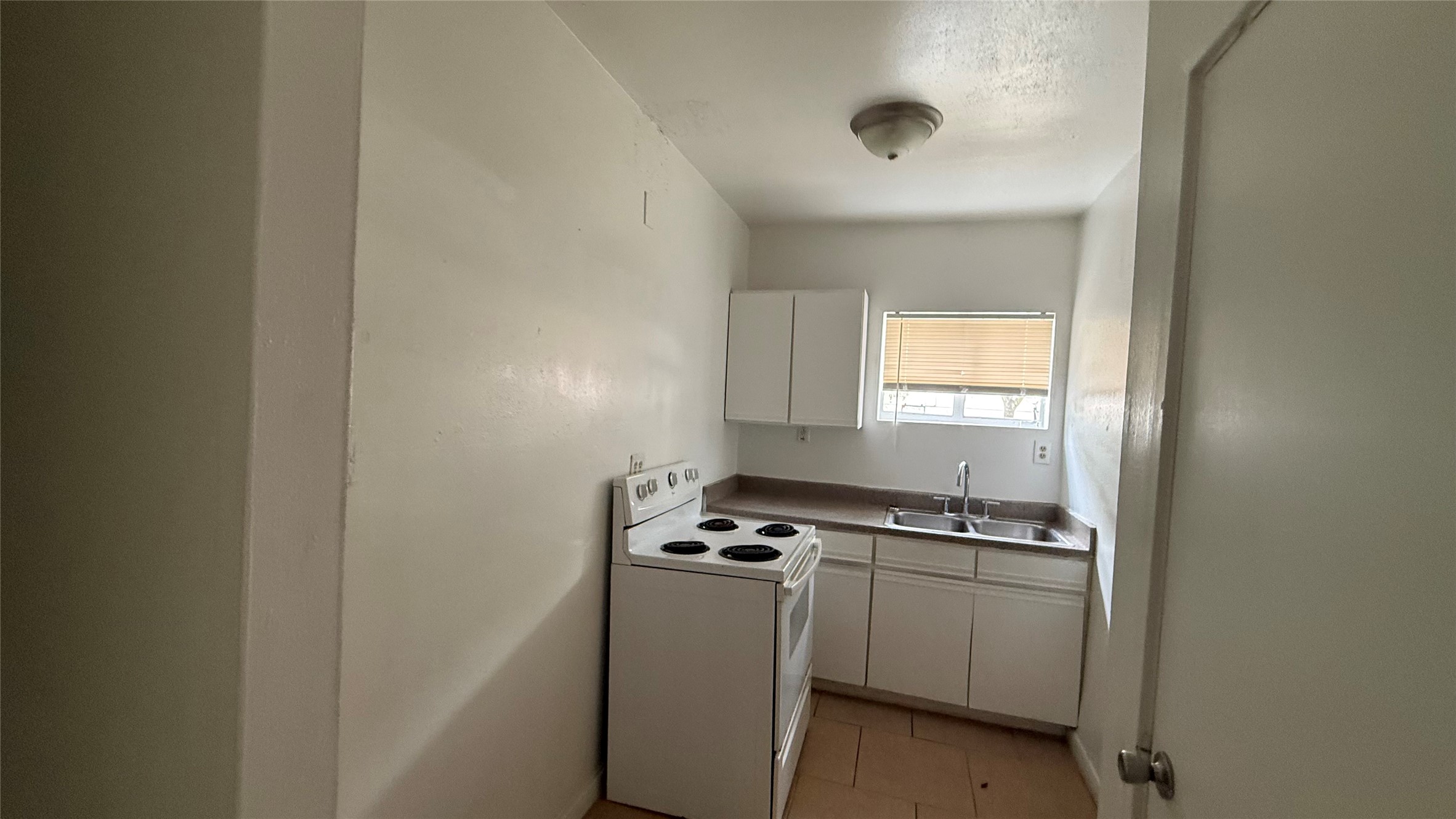 5611 Jackson Street, Unit 1 Houston, TX 77004 - Photo 6 of 7 a kitchen with white cabinets and white appliances