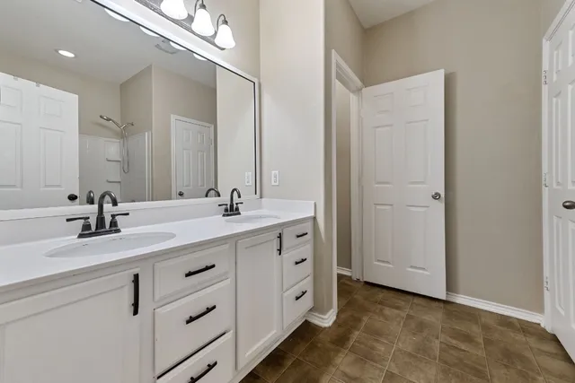 a bathroom with a double vanity sink and mirror