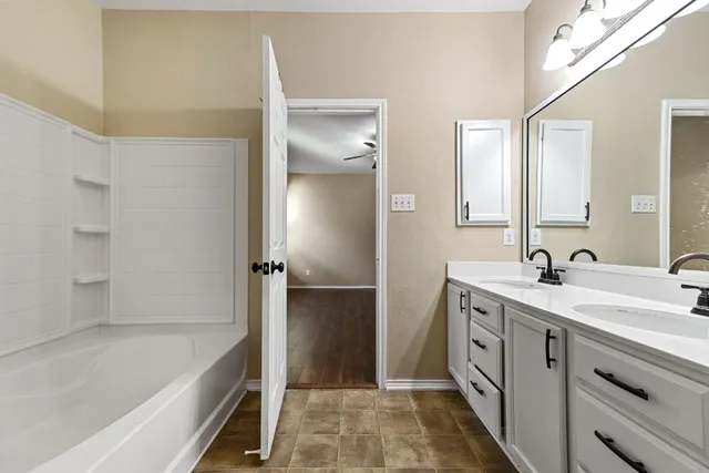 a bathroom with a tub sink and mirror
