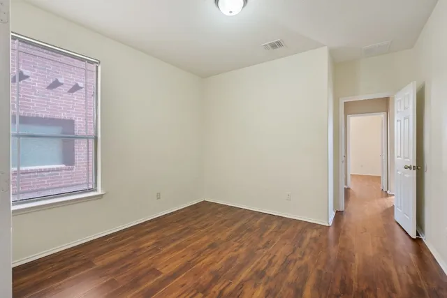 a view of a hallway with wooden floor and closet
