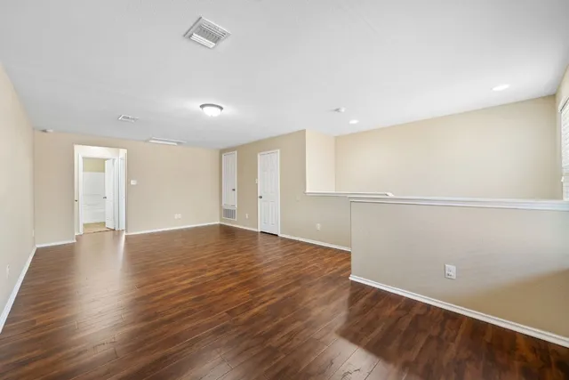 a view of an empty room with wooden floor
