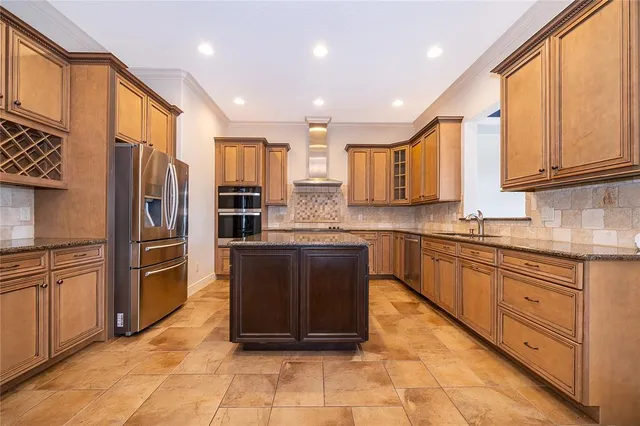 a large kitchen with stainless steel appliances granite countertop a stove and a refrigerator