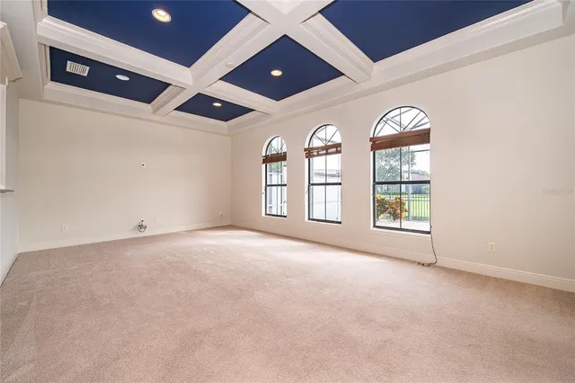 an empty room with windows and ceiling fan