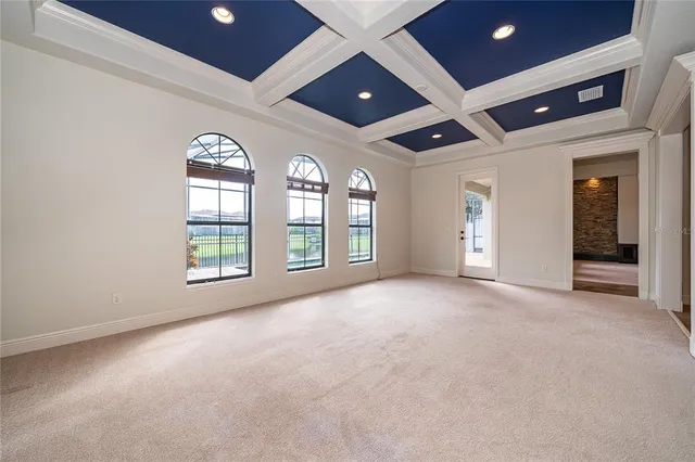 an empty room with windows and ceiling fan