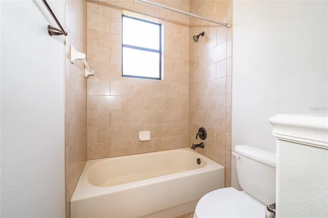 a bathroom with a toilet and a bath tub
